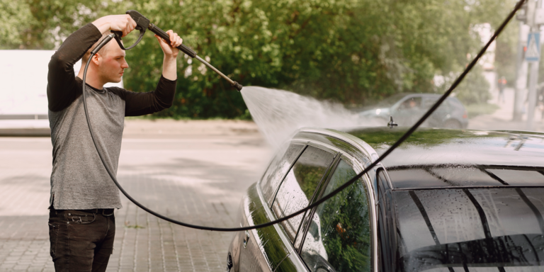 persona utilizando una hidrolimpiadora para limpiar su coche